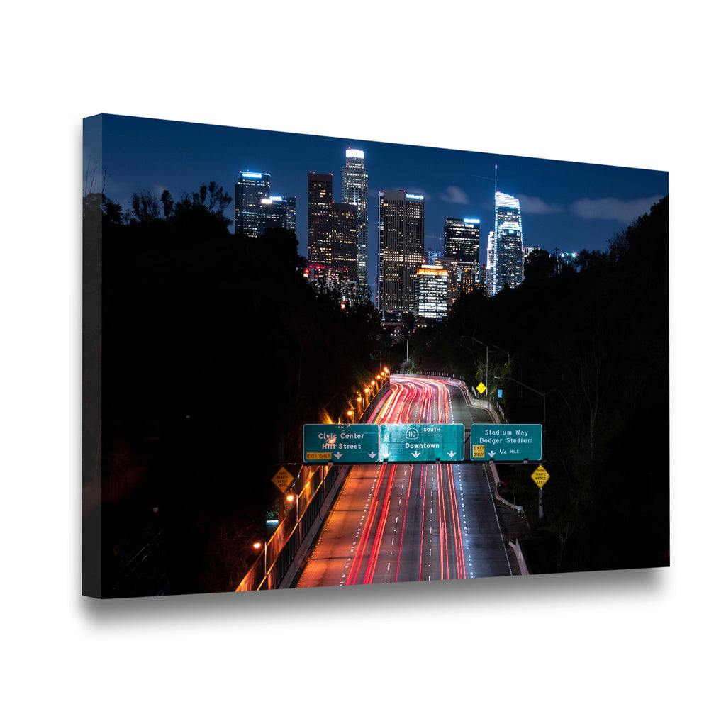 Gallery-wrapped canvas print of Downtown LA freeway at night with glowing skyscrapers and streaking headlights