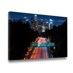 Gallery-wrapped canvas print of Downtown LA freeway at night with glowing skyscrapers and streaking headlights