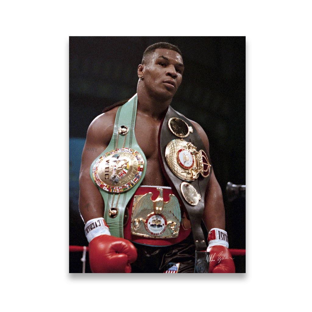 Mike Tyson standing in boxing ring holding three championship belts — WBC, IBF, and WBA — canvas wall art print