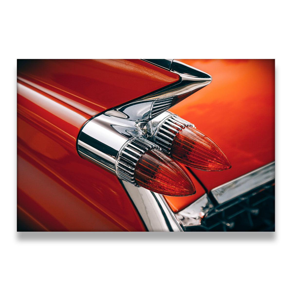 Close-up of a red 1950s classic car tail fin with chrome bullet taillights — retro American automotive canvas wall art
