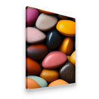 Premium gallery-wrapped canvas wall art of multi-colored smooth pebbles with rich earthy tones, side angle view